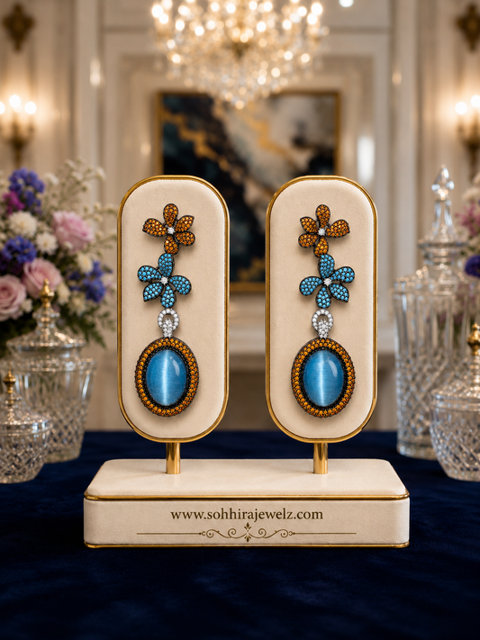 Azure Bloom Cat's Eye Drop Earrings on luxury cream display stand