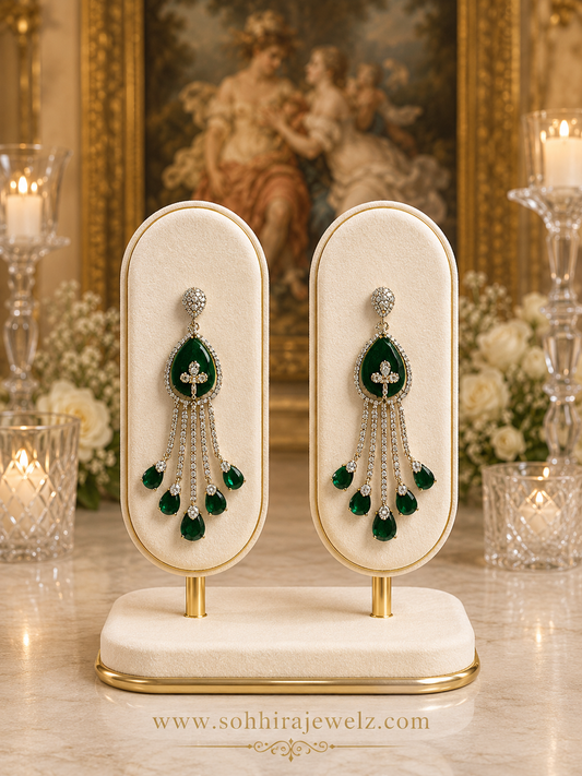 Emerald Cascade Diamond Chandelier Earrings on luxury cream gold oval display stands