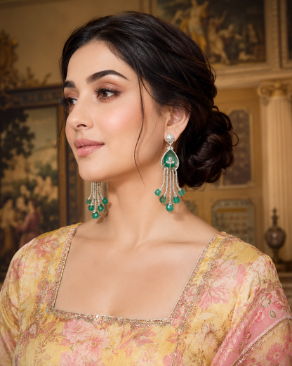 Emerald Cascade Diamond Chandelier Earrings White Gold on luxury cream oval display stands with candles