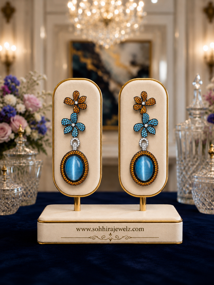Azure Bloom Cat's Eye Drop Earrings on luxury cream display stand